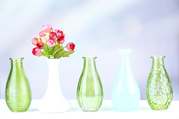 Different decorative vases on shelf on light background — Stock Photo, Image