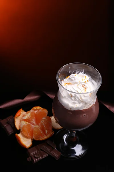 Sabroso postre con chocolate, crema y salsa de naranja, sobre fondo de color oscuro — Foto de Stock