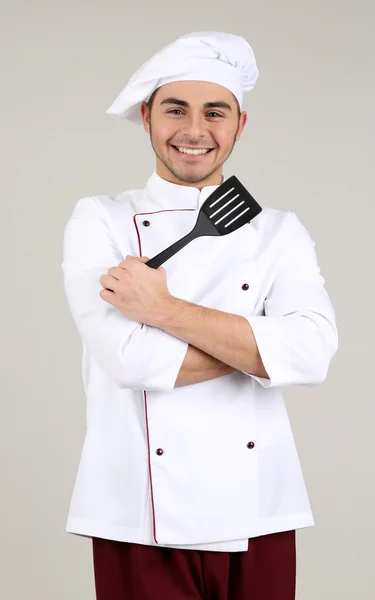 Professional chef in white uniform and hat, on gray background — Stock Photo, Image