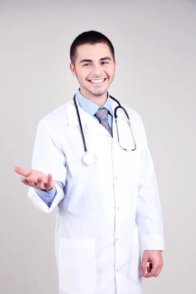 Dottore maschio in piedi su sfondo grigio — Foto Stock
