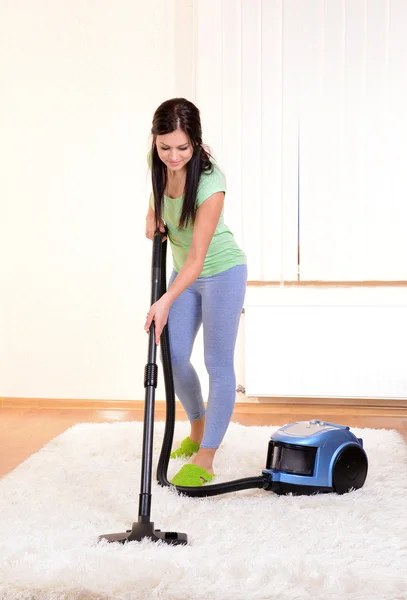 Beautiful young woman with vacuum cleaner in room — Stock Photo, Image