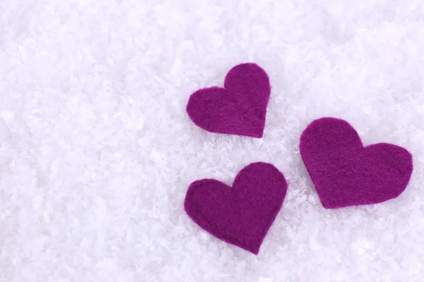 Pequeños corazones sentidos sobre fondo nevado —  Fotos de Stock