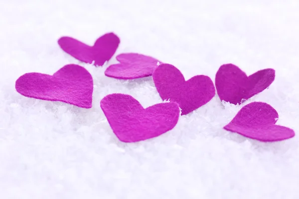 Pequeños corazones sentidos sobre fondo nevado — Foto de Stock