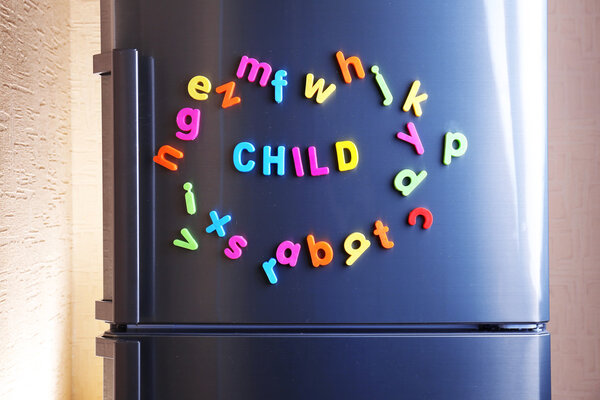 Word Child spelled out using colorful magnetic letters on refrigerator