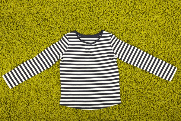 Beautiful shirt for little girl on green carpet — Stock Photo, Image