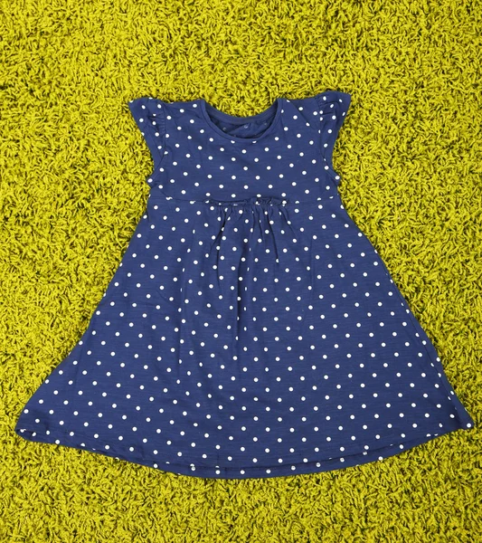 Beautiful dress for little girl on green carpet — Stock Photo, Image