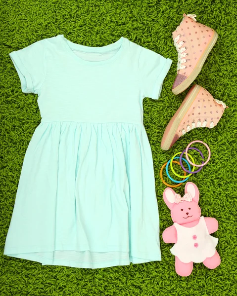 Güzel bir elbise ve lastikbotlar yeşil halı üzerinde küçük kız için — Stok fotoğraf