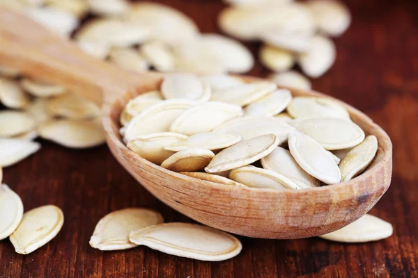 Pumpkin seeds in spoon on table close up — Stock Photo, Image