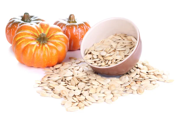 Pompoenpitten in kom met pumpkins geïsoleerd op wit — Stockfoto