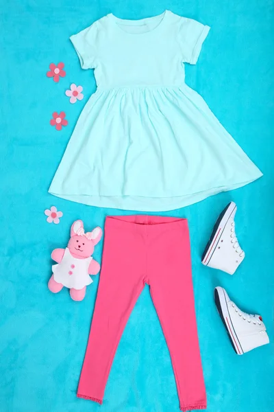 Όμορφα ρούχα για κοριτσάκι σε μπλε φόντο — Φωτογραφία Αρχείου