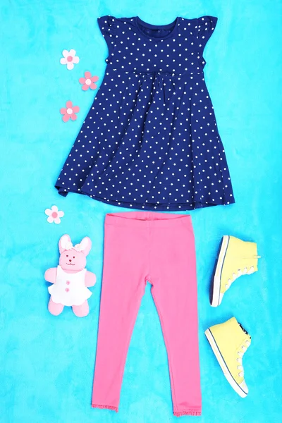 Beautiful clothes for little girl on blue background — Stock Photo, Image