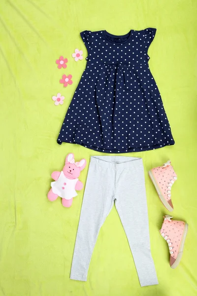 Beautiful clothes for little girl on green background — Stock Photo, Image