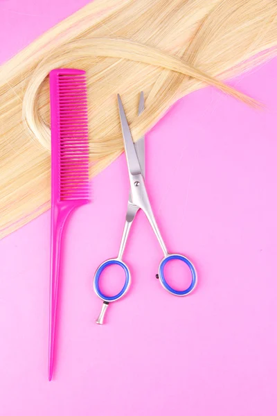 Cabello largo y rubio con tijeras sobre fondo rosa —  Fotos de Stock