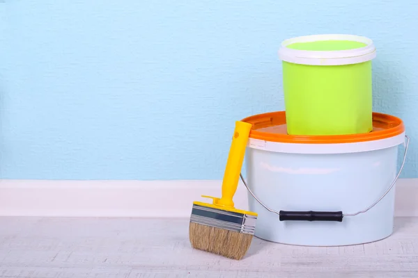 Verf en penseel op verdieping in de kamer op de muur achtergrond — Stockfoto