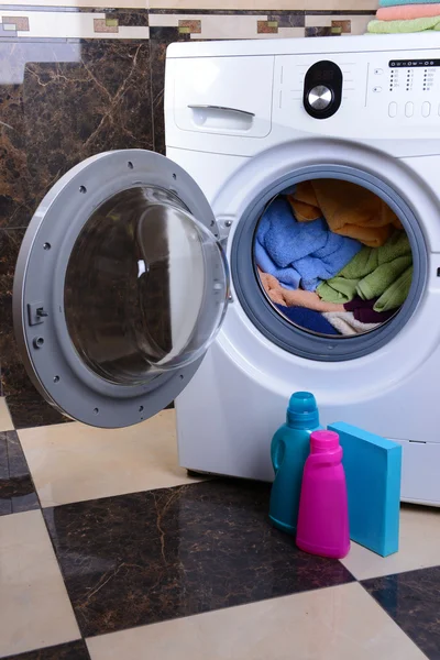 Wasmachine geladen met kleding in badkamer — Stockfoto