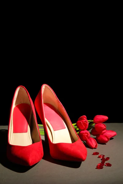 Belle scarpe rosse femminili, su sfondo nero — Foto Stock