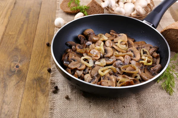 Heerlijke gebakken champignons in pan op tafel close-up — Stockfoto