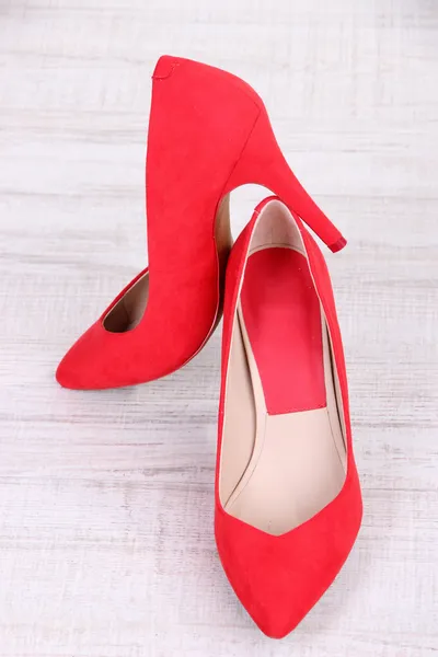 Hermosos zapatos femeninos rojos, sobre fondo de madera — Foto de Stock