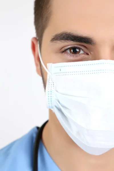 Jovem médico do sexo masculino em máscara médica, close-up, isolado em branco Imagem De Stock