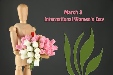 Ahşap manken buket gri arka plan üzerinde tutan