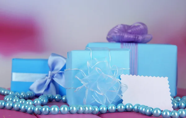 Cajas de regalo con etiqueta en blanco y chaplet en la mesa sobre fondo brillante —  Fotos de Stock