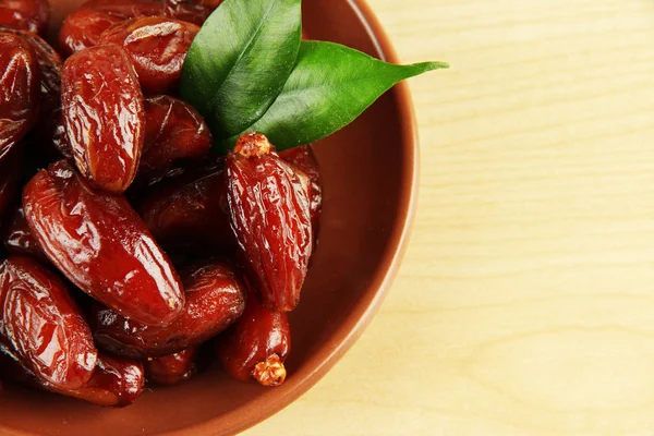 Dried dates on plate on wooden background — Stock Photo, Image