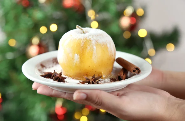 Hände halten Teller mit gebackenem Apfel, auf hellem Hintergrund — Stockfoto