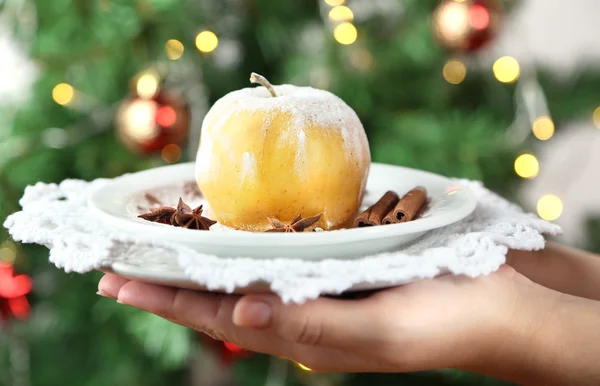 Hände halten Teller mit gebackenem Apfel, auf hellem Hintergrund — Stockfoto