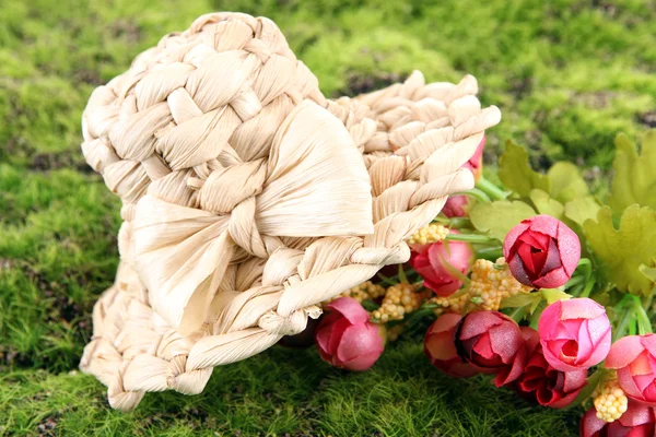 Small straw hat with flowers, on green moss — Stock Photo, Image