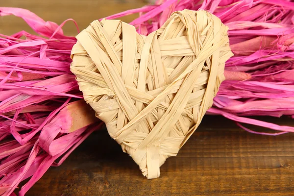 Paja decorativa para la mano y corazón de paja, sobre fondo de madera — Foto de Stock