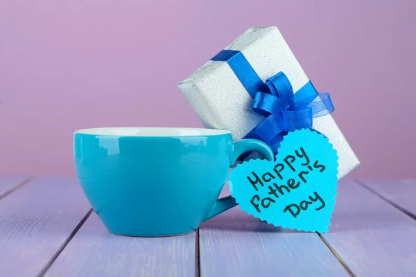 Gelukkig vaders dag tag met de doos van de gift en cup, op houten tafel, op lichte achtergrond — Stockfoto