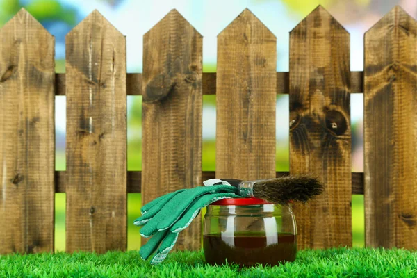 Aplicando barniz protector a valla de madera, sobre fondo brillante — Foto de Stock