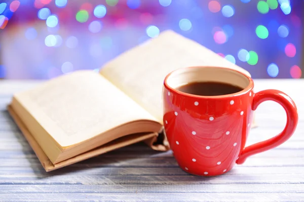 Composition of book with cup of coffee on table on bright background — Stock Photo, Image