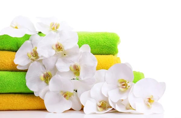 Colorful towels and orchid flowers, isolated on white — Stock Photo, Image