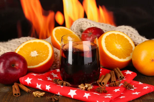 Fragrant mulled wine in glass on napkin on fire background — Stock Photo, Image