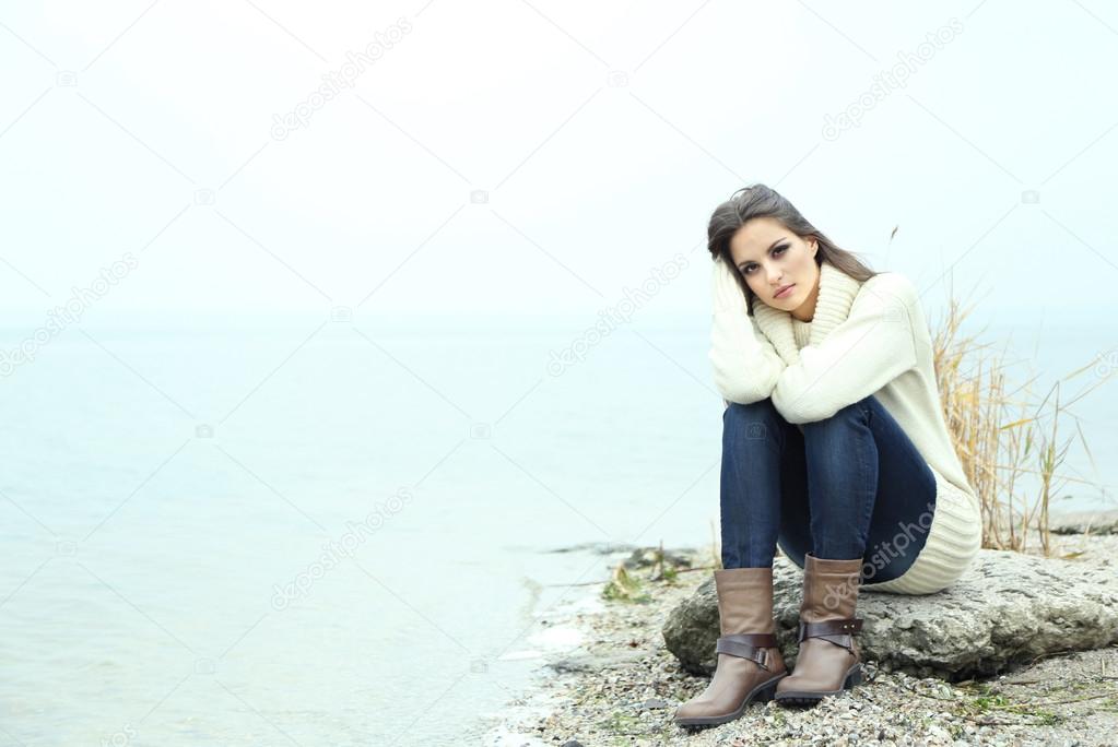 Portrait of young serious woman near river
