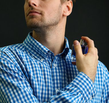 siyah arka plan üzerine parfüm kullanma yakışıklı genç