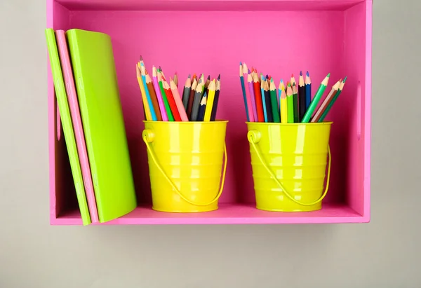 Lápis coloridos em pails na prateleira no fundo bege — Fotografia de Stock