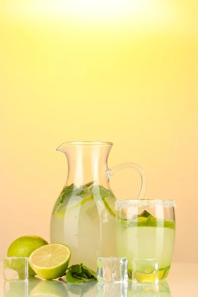 Limonada en jarra y vaso sobre fondo amarillo — Foto de Stock