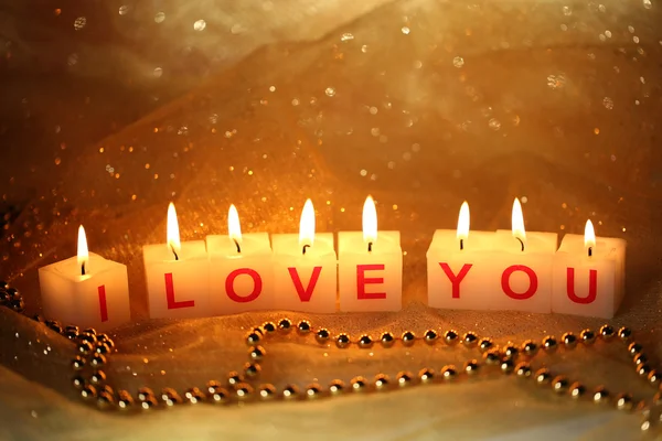 Candles with printed sign I LOVE YOU, on blur lights background — стоковое фото