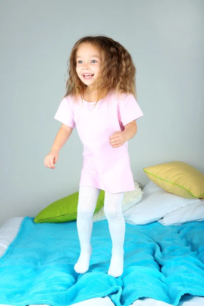 Klein meisje springen op bed — Stockfoto