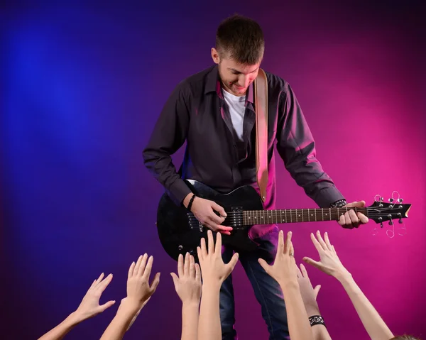 Gitarist zingen op het podium van een rockconcert voor zijn bewonderende fans — Stockfoto