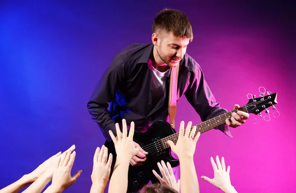그의 열혈 팬 들을 위해 록 콘서트에서 무대에서 노래 하는 기타리스트 — 스톡 사진