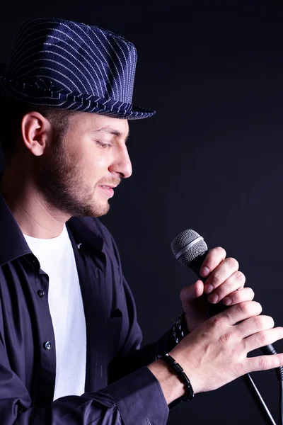 Молодий музикант співає на сірому фоні — стокове фото