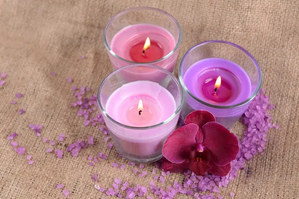 Composição com belas velas coloridas, sal marinho e flores de orquídeas, em fundo de madeira — Fotografia de Stock