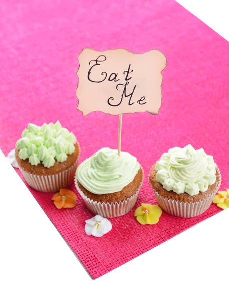 Sabrosos cupcakes con crema de mantequilla, en servilleta de color, aislado en blanco —  Fotos de Stock
