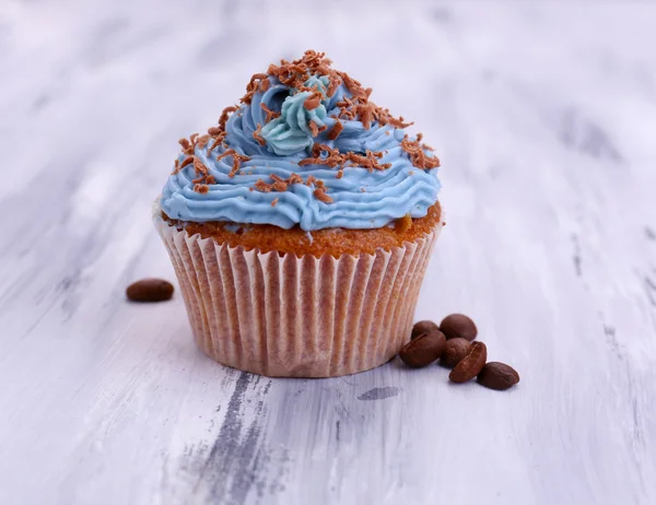 Smakelijke cupcake met boter room, op een houten achtergrond kleur — Stockfoto