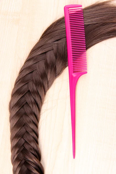 Long brown hair with comb on wooden background — Stock Photo, Image