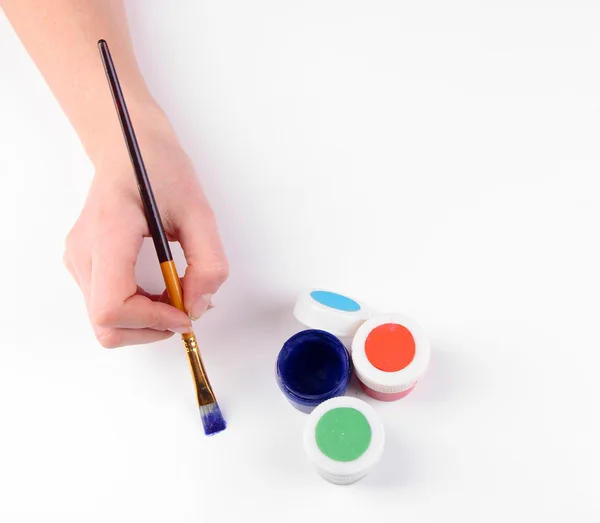 Hand hält Pinsel mit Farben isoliert auf weiß — Stockfoto