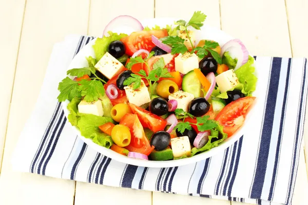 Frischer Salat im Teller auf Holztisch — Stockfoto